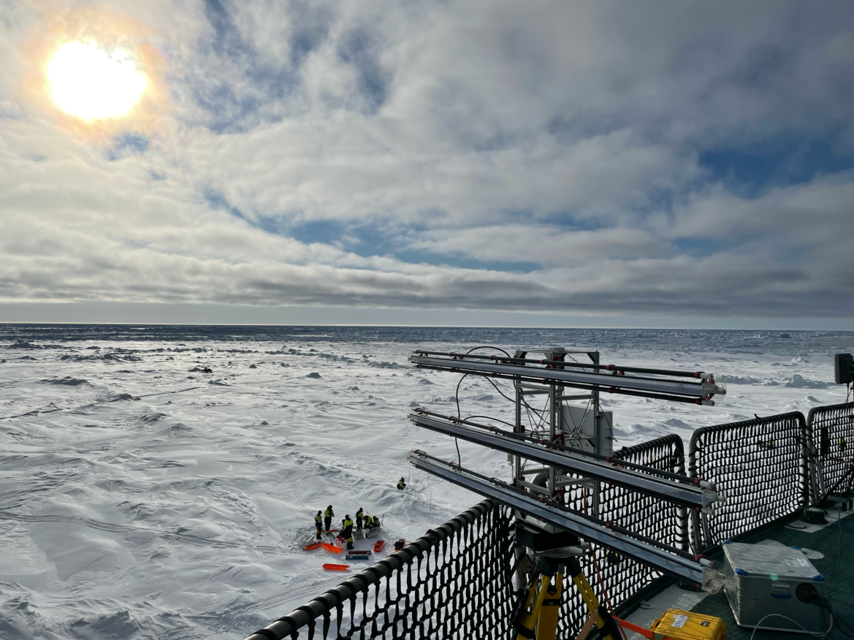 Tom Rune Lauknes, Ku-band radar samler inn radarbilder av isforholdene rundt fartøyet., Cirfa 7343, <p>NORCE</p>, Ser ut over ripa på en båt og utover et islagt havområde. Ute på isen en klynge med mennesker.