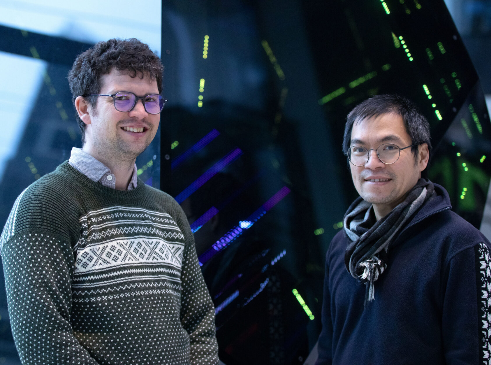 Thomas Hovmøller Ris, Damien Couespel and Jerry Tjiputra, Damien og Jerry 2 copy, <p>Photo: Thomas Hovmøller Ris</p>, Two men facing the camera with a glass showcase looking like alghorithms in the background
