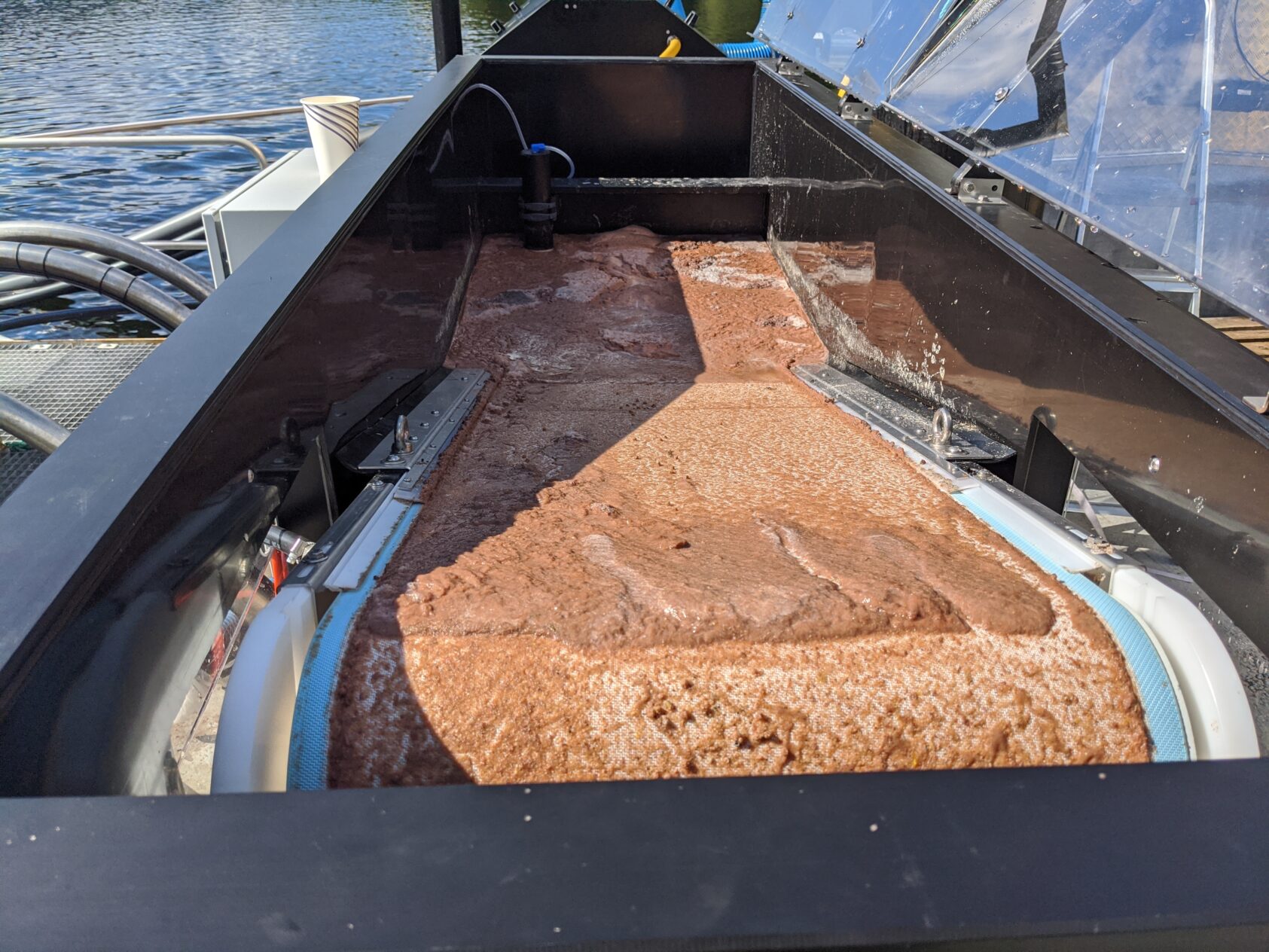 Jarle Ragnhildstveit, Framo, Slam samlet opp med Framo LiftUp-systemet, Slam samlet opp fra Framo Lift Up systemet foto Framo Lift UP, <p>Jarle Ragnhildstveit, Framo</p>, Brun masse på et samlebånd.