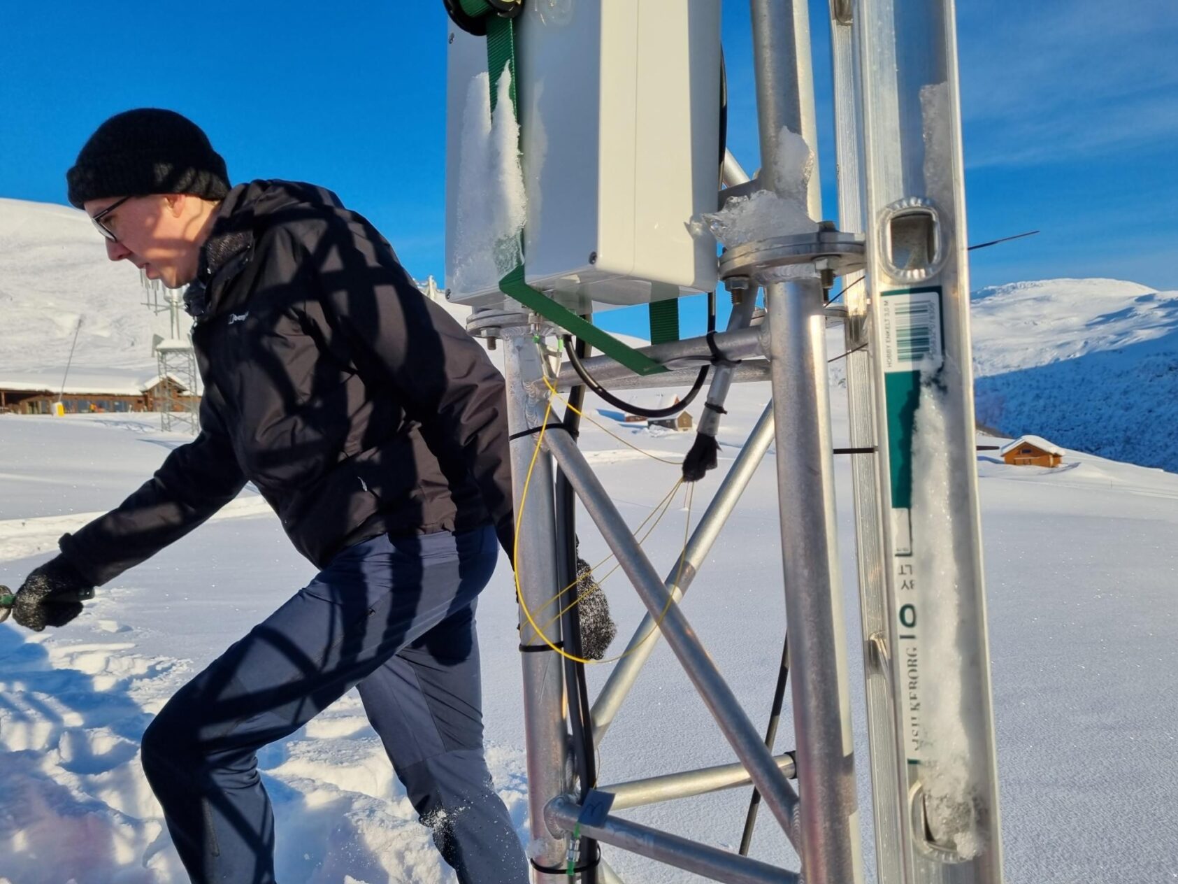 Peter James Thomas, NORCE, Her ser vi NORCE-forsker, Adam Funnell, og en del av teknikken som fanger opp og sender videre signalene fra sensorene som ligger på bakken under snøen., 20230119 113246, , 