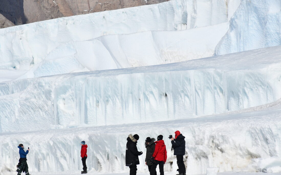 stor isvegg med mennesker under