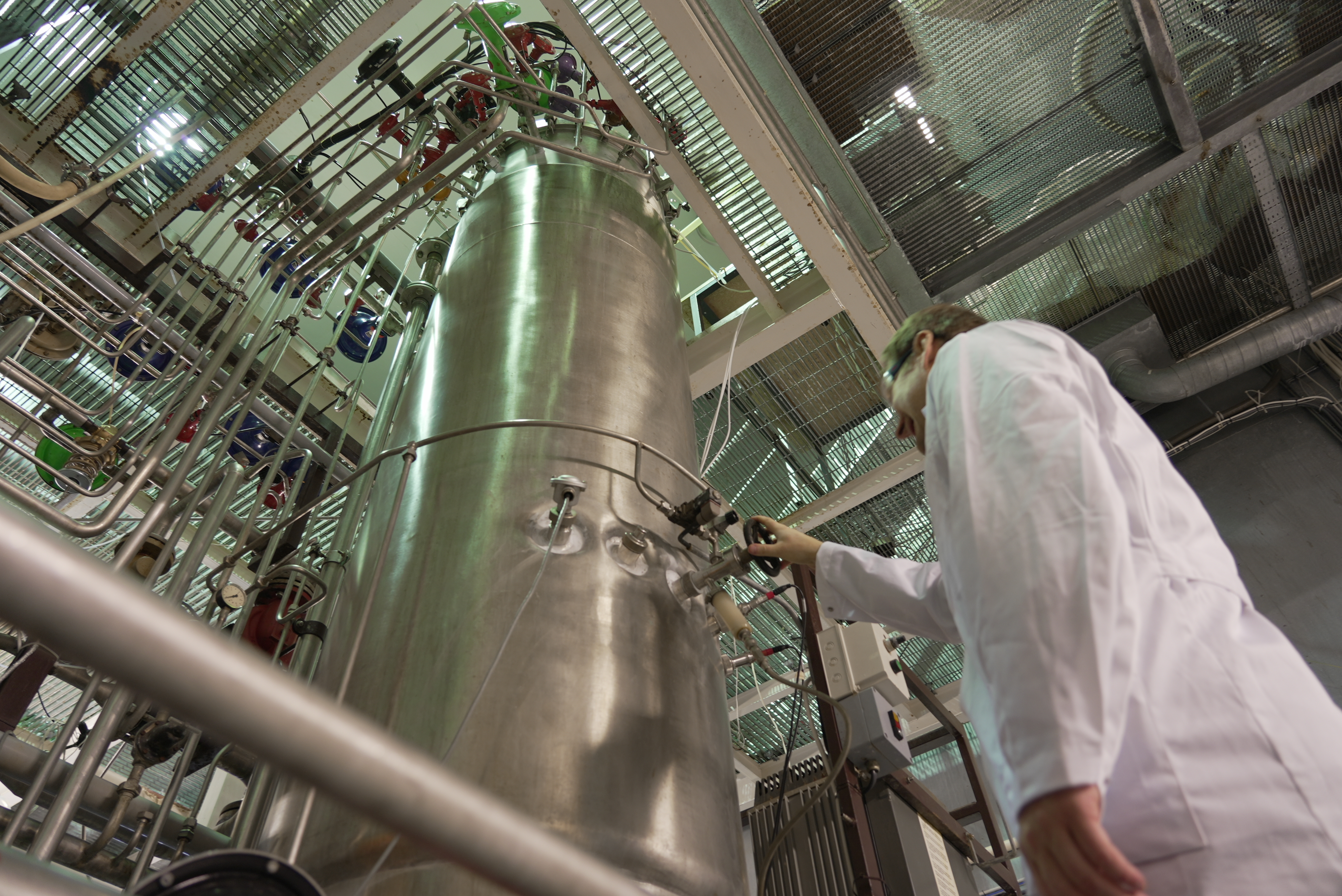 NORCE, Fermentation tank at the Norwegian Bioprocessing and Fermentation Centre in Risavika, Risavika_fermenteringstank_DSC02820, <p>NORCE</p>, Ståltank med mange rør, mann i forskerfrakk vrir på et hjul. Foto