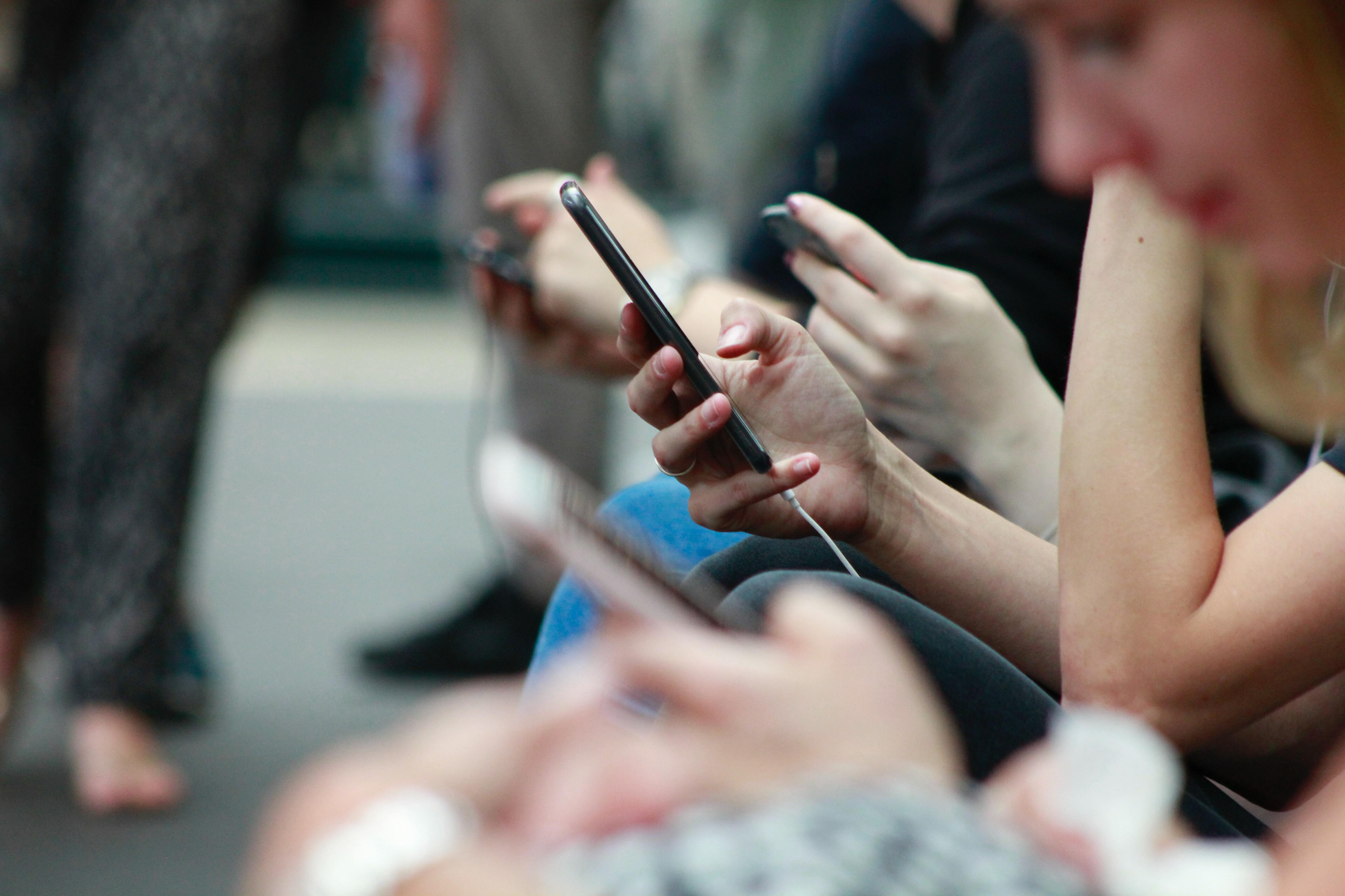 , Illustrasjonsbilde: Robin Warroll/Unsplash., Media poverty illustrasjon, , Close up of hands holding mobile phones.